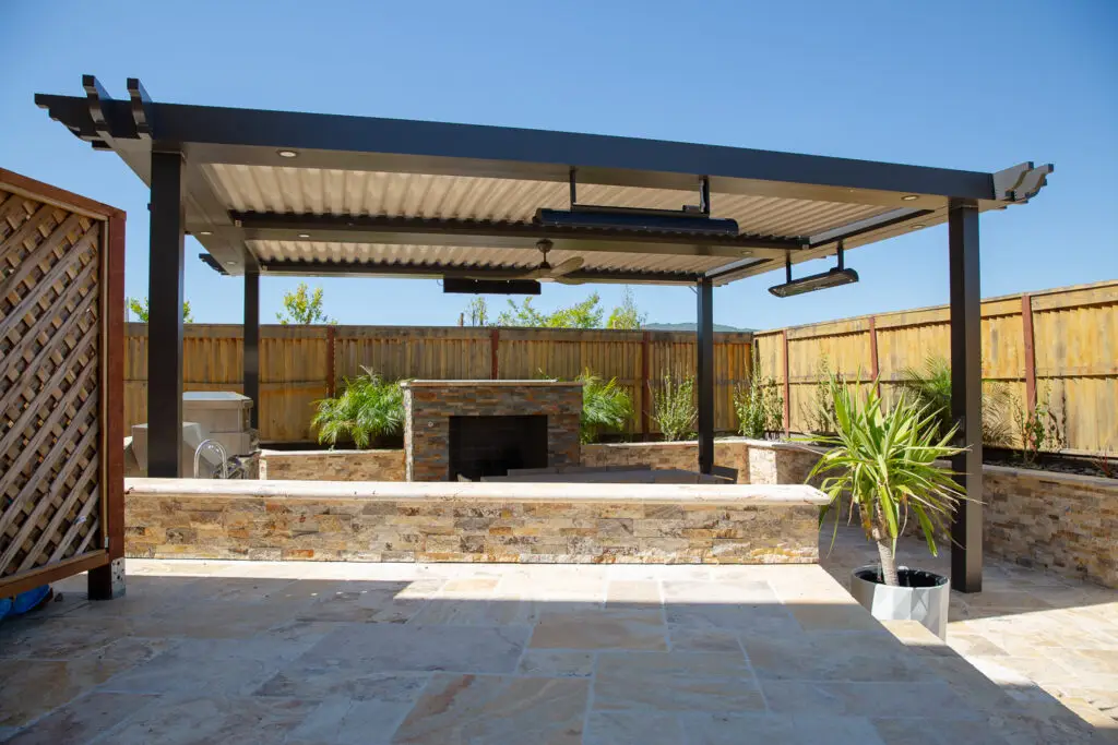 Stone bar and fireplace beneath a StruXure pergola in a Danville, CA backyard