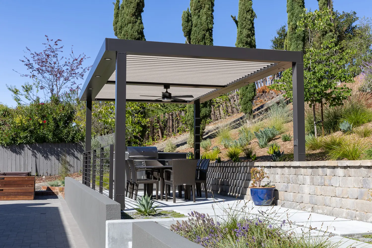 Motorized StruXure pergola over a terraced hillside patio with dining and grill in Orinda, CA