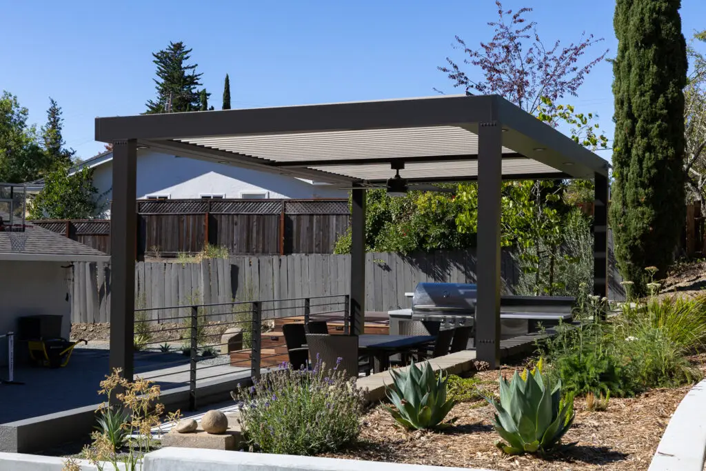 StruXure pergola patio with a built-in grill framed by agave and lavender landscaping in Orinda, CA