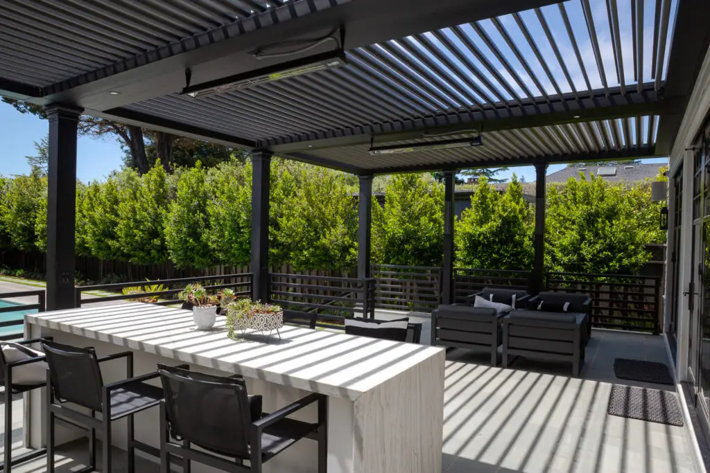 Waterfall-edge outdoor bar counter beneath a StruXure pergola in San Mateo, CA