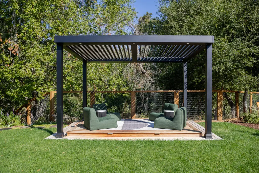 Green modular lounge seating beneath a StruXure pergola with wood lattice fencing in Saratoga, CA