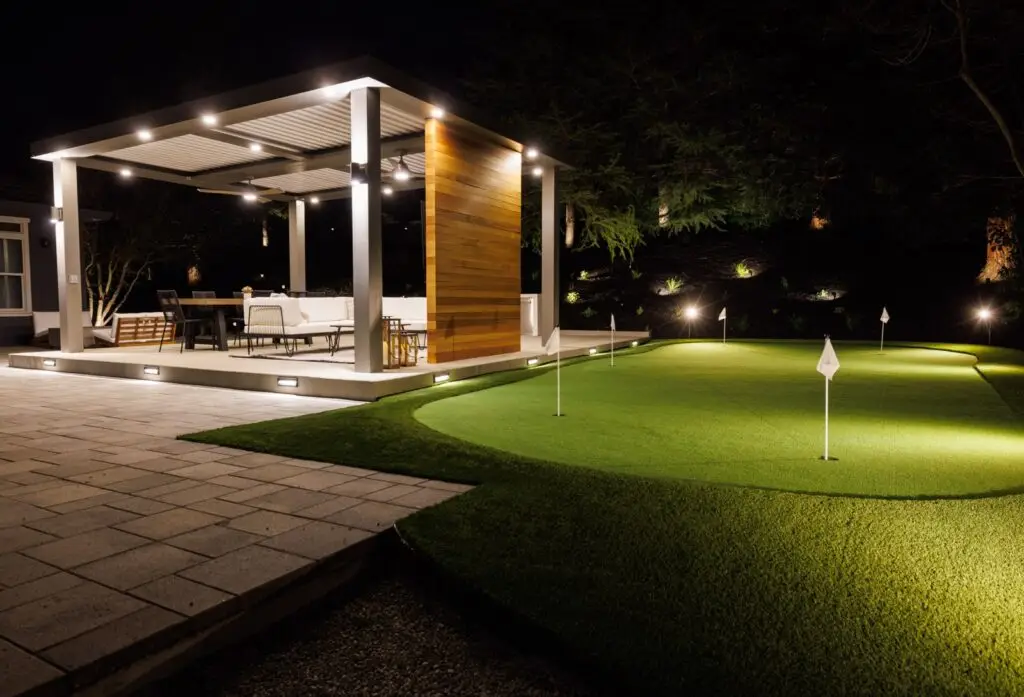 StruXure pergola patio opening onto a lit multi-hole putting green in Walnut Creek, CA