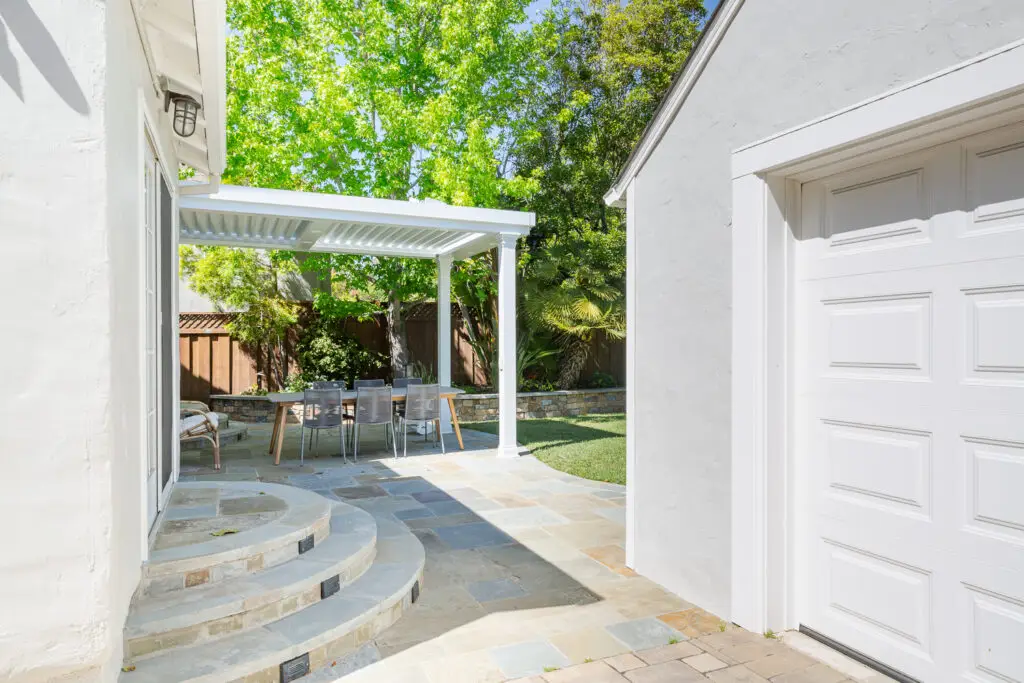 StruXure pergola over a dining table beside the garage in a Burlingame backyard